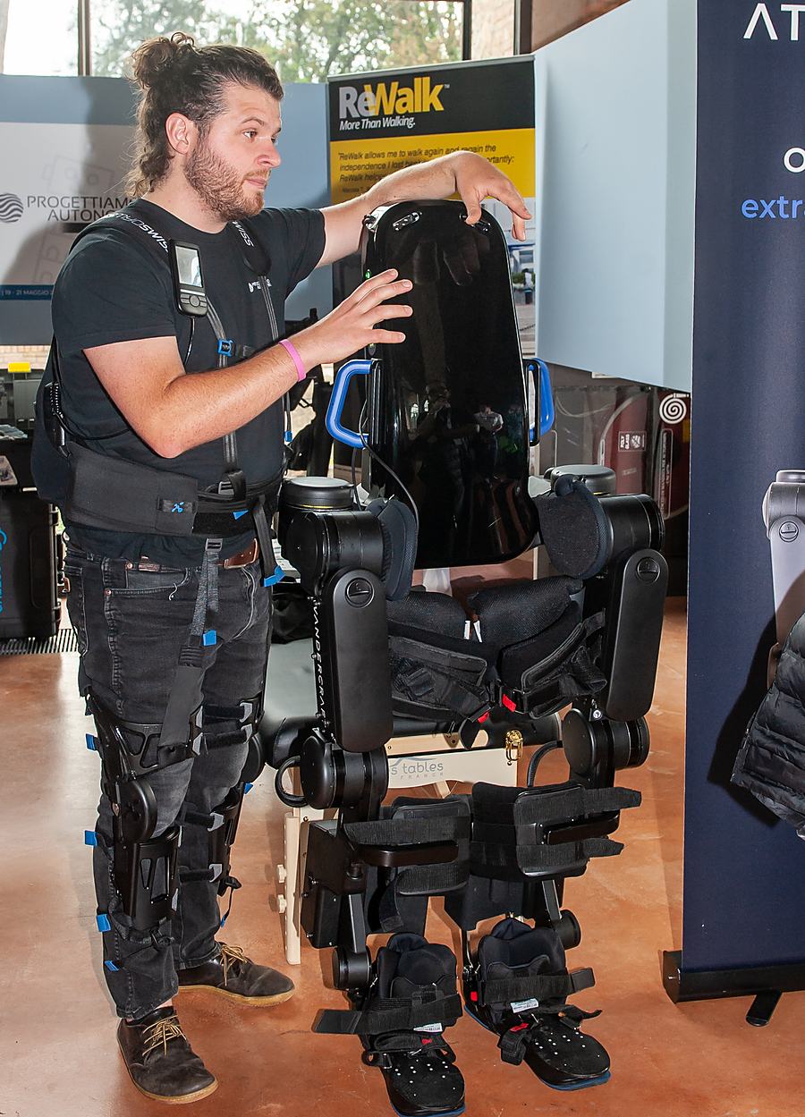 Una persona indossa un esoscheletro robotico per gli arti inferiori in una dimostrazione: tecnologia assistiva e robotica per la mobilità nella disabilità.